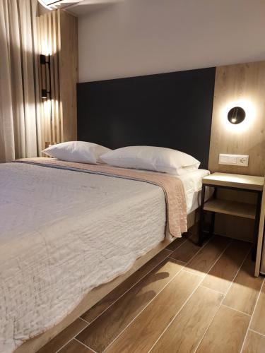 a bedroom with a large bed with white sheets and pillows at EUPHORIA ''Staying in Pleasure'' in Paralia Katerinis