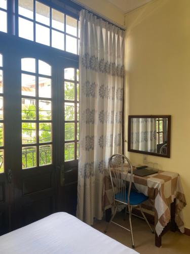 a bedroom with a bed and a desk and a window at Bao Minh Hotel in Hue