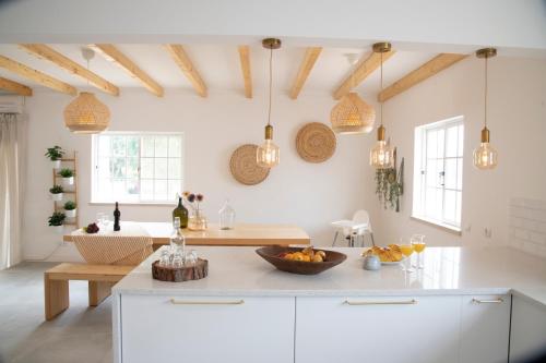 una cocina con armarios blancos y luces colgantes en Casa Portus - Turismo Rural, en Faro