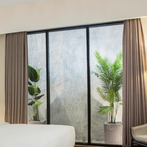 a room with a window with two potted plants at Swiss-Belinn Singkawang in Singkawang