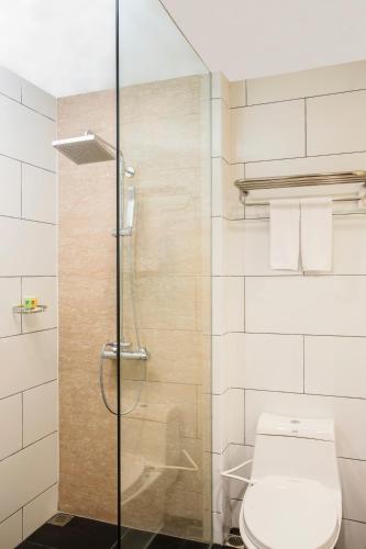 a bathroom with a toilet and a glass shower at Swiss-Belinn Singkawang in Singkawang