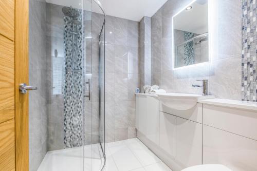 Un baño con ducha, inodoro y lavabo. en Seafront 2 Bedroom Apartment, en Portsmouth