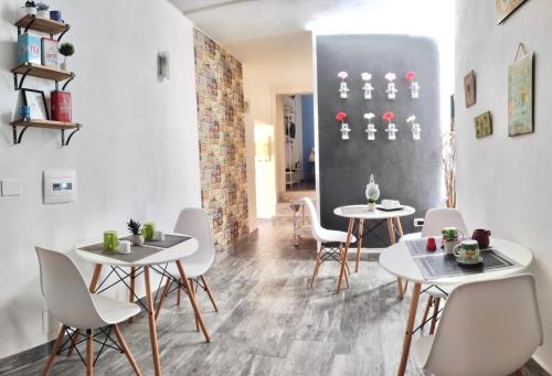 a dining room with two tables and white chairs at Domus Rubra in Castelsardo