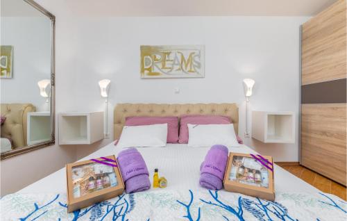 a bedroom with a large bed with purple pillows at Lovely Home In Sarici With Heated Swimming Pool in Divšići