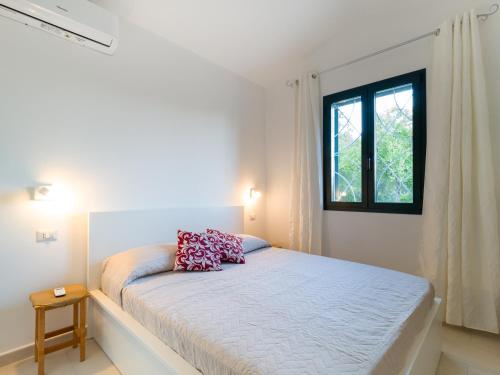 una camera bianca con un letto e una finestra di Country Lodge - Klodge a Olbia