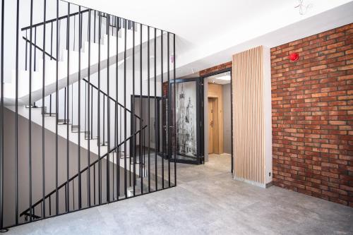 a staircase in a room with a brick wall at Iron Apartments by MB Apartments in Krakow