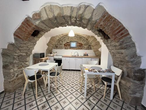 a kitchen with tables and chairs in a stone wall at Vitamin K73 Vendégház in Boldogkőváralja