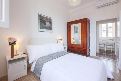 ein weißes Schlafzimmer mit einem weißen Bett und einem Fenster in der Unterkunft Apartments Florence - Florentine Skyline in Florenz