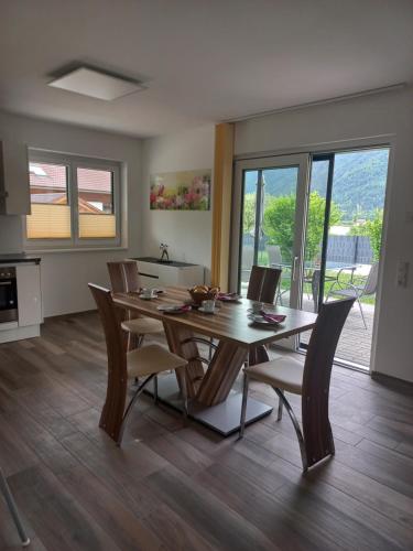 cocina y comedor con mesa de madera y sillas en Ferienhaus Natura 2000, en Steindorf am Ossiacher See