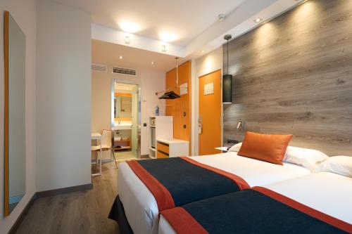 Un pat sau paturi într-o cameră la Catalonia Mikado