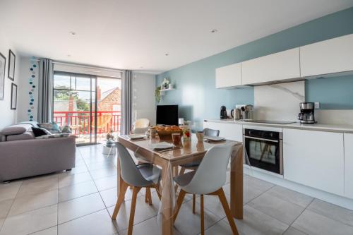 une cuisine et un salon avec une table et des chaises dans l'établissement Appartement moderne pour 4 à deux pas de la plage, à Pléneuf-Val-André