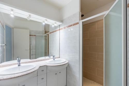 une salle de bain avec deux lavabos et une douche dans l'établissement Villa piscine pour 8 à Lacanau, à Lacanau