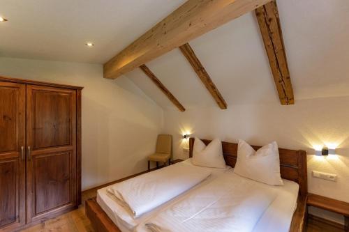 a bedroom with a bed with white sheets and pillows at Maisonett - Appartement 201 in Bichlbach