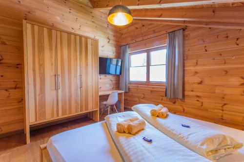 a bedroom with two beds in a log cabin at Chalet Huber by Alpenidyll Apartments in Aich