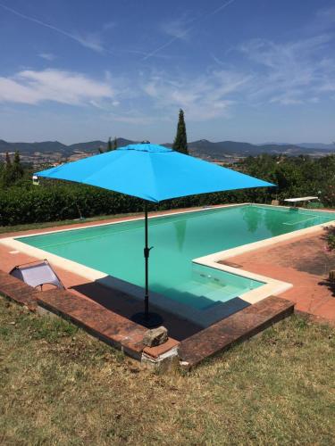 Una gran sombrilla azul en una piscina. en Casa Palombella, en Cibottola