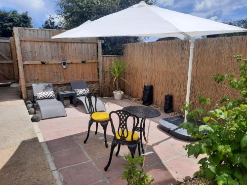 a patio with a table and chairs and an umbrella at Woodside Annexe in Paignton