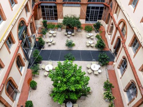 an overhead view of a courtyard with tables and plants at Ibis Styles Toulouse Capitole in Toulouse