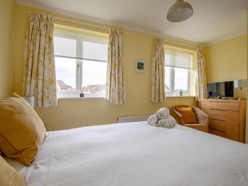 Un dormitorio con una gran cama blanca con un osito de peluche. en Pass the Keys Cheerful and modern one bedroom home with parking, en Shrewsbury