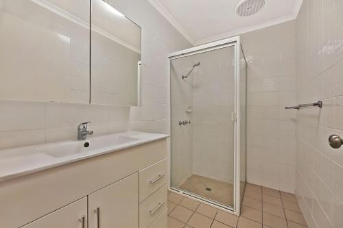 ein weißes Bad mit einem Waschbecken und einer Dusche in der Unterkunft 2 bedroom townhouse one street away from the beach in Buddina