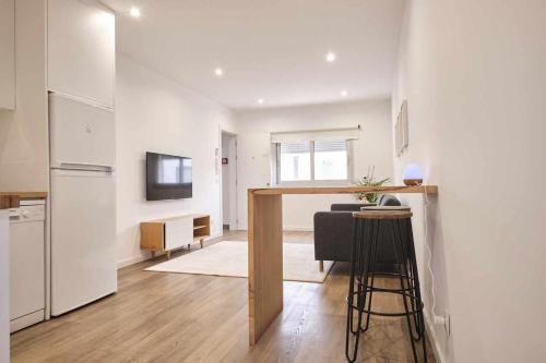 a kitchen and living room with a table and a refrigerator at Casas do Portinho in Marinha Grande