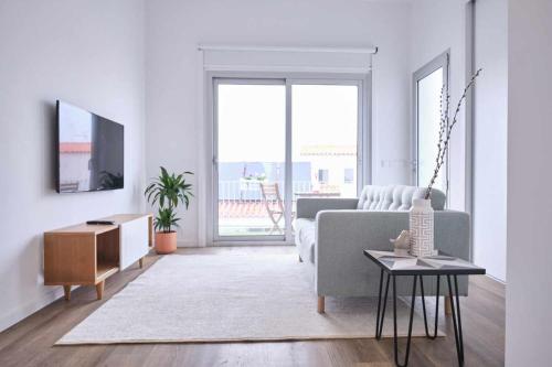 a living room with a couch and a tv at Casas do Portinho in Marinha Grande