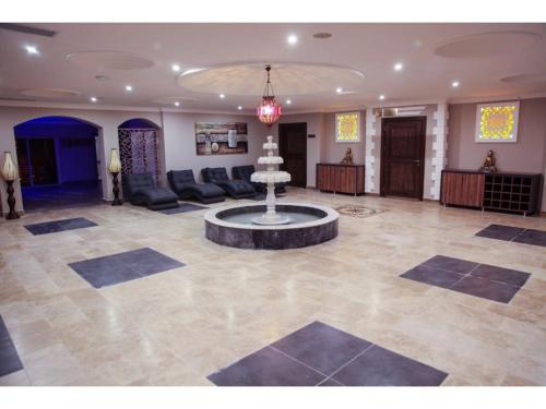 a lobby with a fountain in the middle of a room at Jasmine Court Hotel & Casino in Kérynia