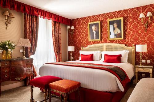 - une chambre avec un grand lit et du papier peint rouge dans l'établissement Hotel De Seine, à Paris