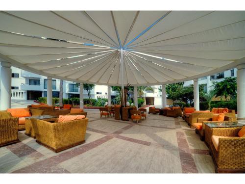 a large umbrella over a patio with chairs and tables at Jasmine Court Hotel & Casino in Kérynia