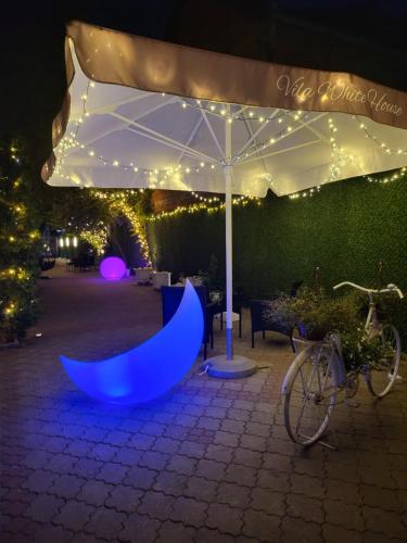 a blue object is under an umbrella at night at Apartments & Pool Villa White House in Pančevo
