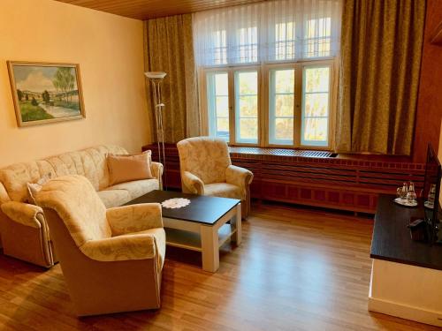 a living room with a couch and chairs and a table at Forsthaus Siehdichum in Dammendorf