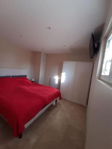 - une chambre avec un lit rouge et une fenêtre dans l'établissement T3 Les Issambres vue mer. Vélos, paddles sur place, aux Issambres