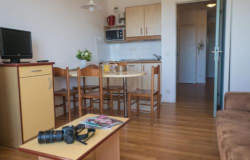 uma sala de estar com uma cozinha e uma mesa com uma máquina fotográfica em Studio cabine résidence 4 étoiles piscine tennis golf parking privé em Bidart