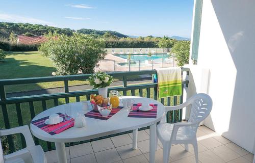 uma mesa branca e cadeiras numa varanda em Studio cabine résidence 4 étoiles piscine tennis golf parking privé em Bidart