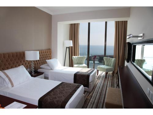 a hotel room with two beds and a window at Denizkizi Hotel in Kérynia