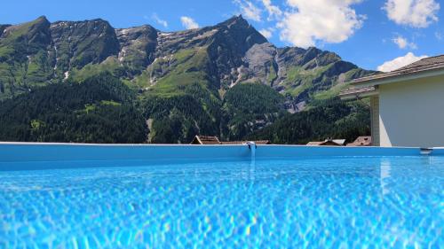 a swimming pool with mountains in the background at Gasthaus Alpina in Tschappina