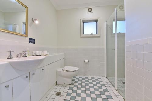 y baño con aseo, lavabo y ducha. en Villa 2br Pinot Nois Villa located within Cypress Lakes Resort, en Pokolbin