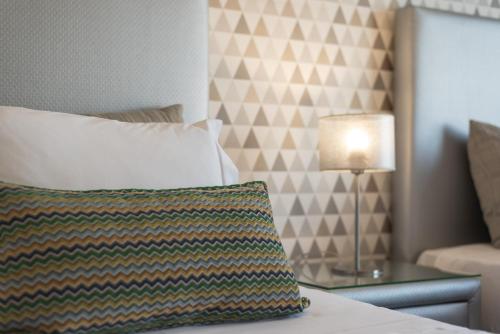 a bed with a pillow and a table with a lamp at Casa Dona Maria - Armamar Douro in Armamar