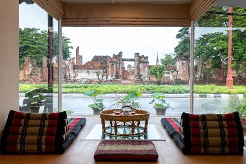 a room with a large window with a view of a temple at One Dhatu Ayutthaya Premium Homestay in Phra Nakhon Si Ayutthaya