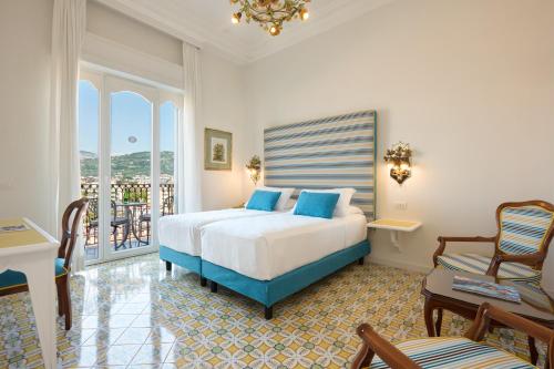 a bedroom with a bed and a balcony at Grand Hotel Capodimonte in Sorrento