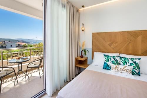 a bedroom with a bed and a balcony with a table at Alia Comfort Style Studios in Limenaria