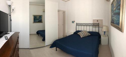 1 dormitorio con cama azul y espejo en Cà Mea, en Alberobello