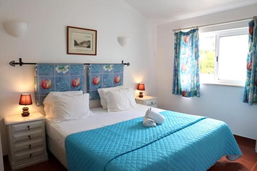 Villa Quintinha في Mexilhoeira Grande: غرفة نوم مع سرير أزرق مع اللوح الأمامي الأزرق