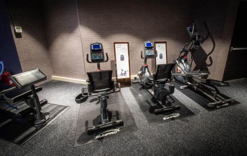 a gym with three exercise bikes and three cell phones at Golden Tulip FAB Hotel New Taipei in Tamsui