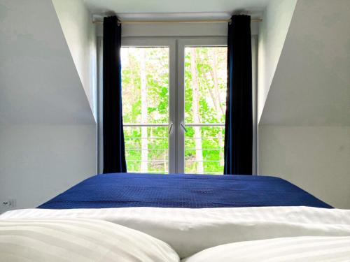 a bedroom with a bed and a large window at Domki Meer Dziwnówek in Dziwnówek