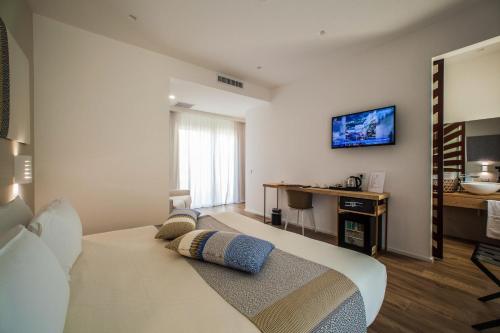 a bedroom with a bed and a desk and a television at NOHA Lifestyle Hotel - Adults Only in Pula