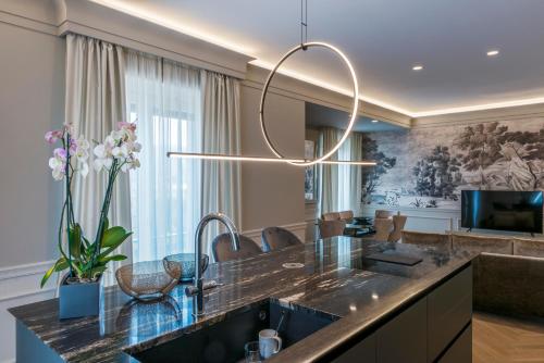 kuchnia z dużą wyspą z żyrandolem w obiekcie Villa Vitae - Alba Pompeia - Luxury apartment w Albie