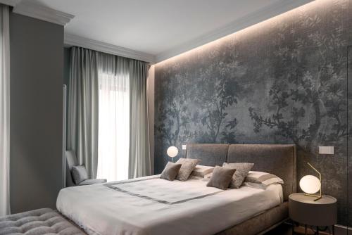 sypialnia z dużym łóżkiem i obrazem na ścianie w obiekcie Villa Vitae - Alba Pompeia - Luxury apartment w Albie