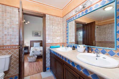 a bathroom with two sinks and a mirror at Villa Torreon Faro by Villa Plus in Mijas Costa