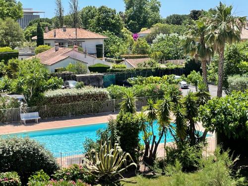 a swimming pool in a yard with trees and plants at Studio de standing climatisé, avec piscine, proche de la mer in Fréjus