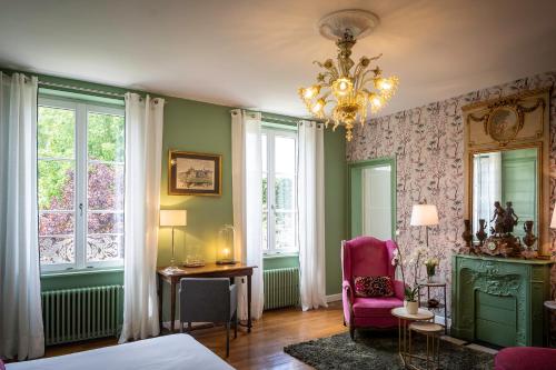 een kamer met een bed, een stoel en ramen bij Le Petit Matin in Bayeux